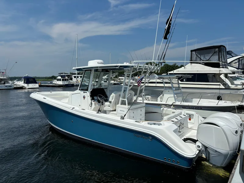 Slide: The Image of 2023 Edgewater 285CC boat docked at marina on a sunny day. - 2