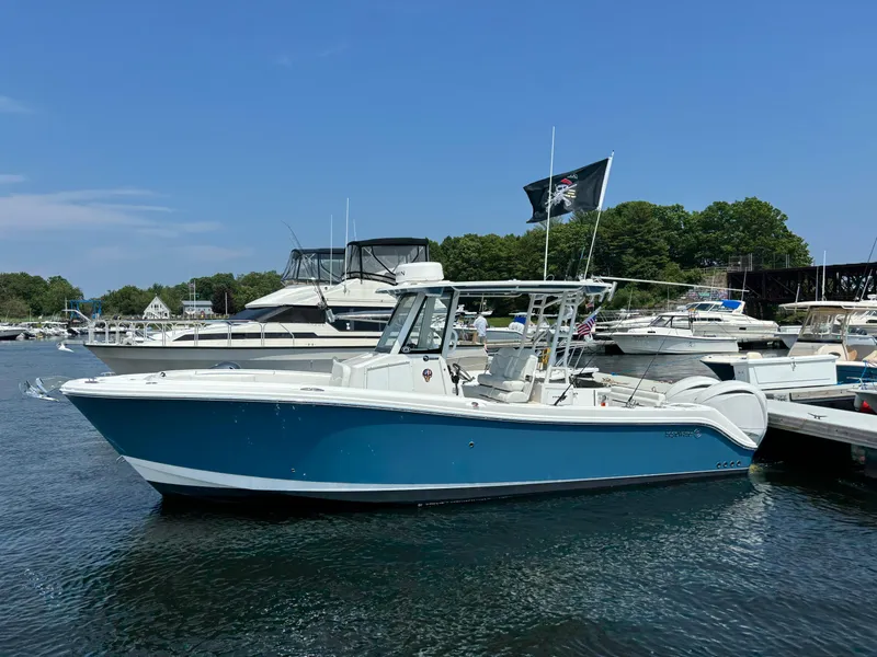 Slide: The Image of 2023 Edgewater 285CC boat docked in a marina on a sunny day. - 3