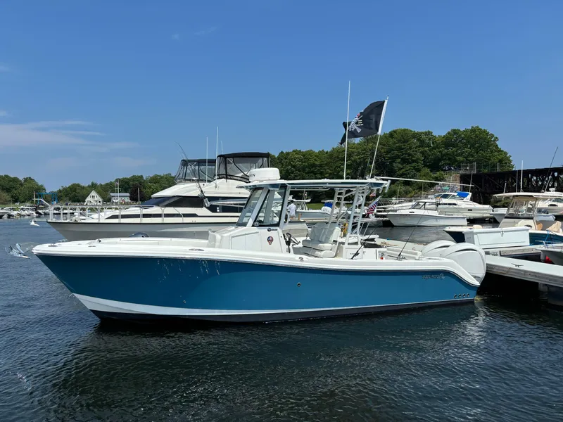 Slide: The Image of 2023 Edgewater 285CC boat docked in a marina on a sunny day. - 6