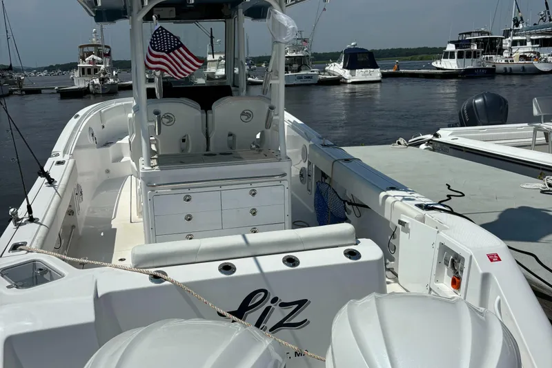 Slide: The Image of 2023 Edgewater 285CC boat docked at marina with American flag. - 8