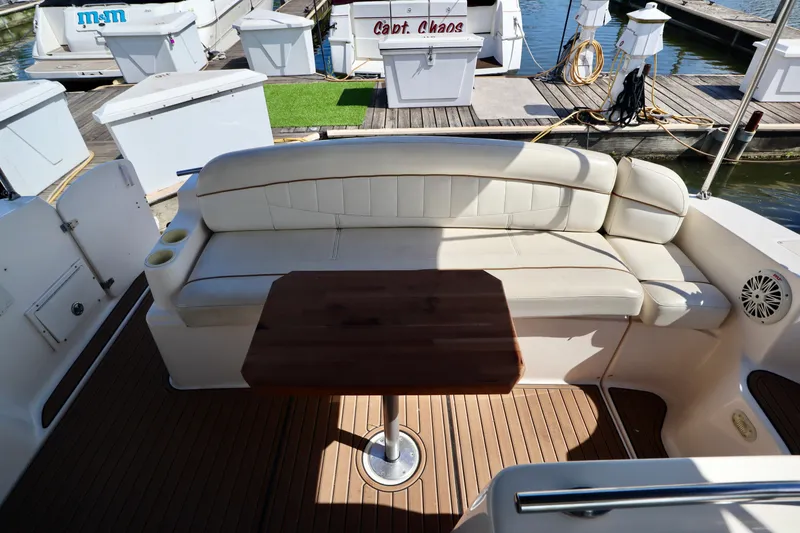 Slide: The Image of 2002 Rinker 342 Fiesta Vee boat interior with white seating and wooden table. - 15