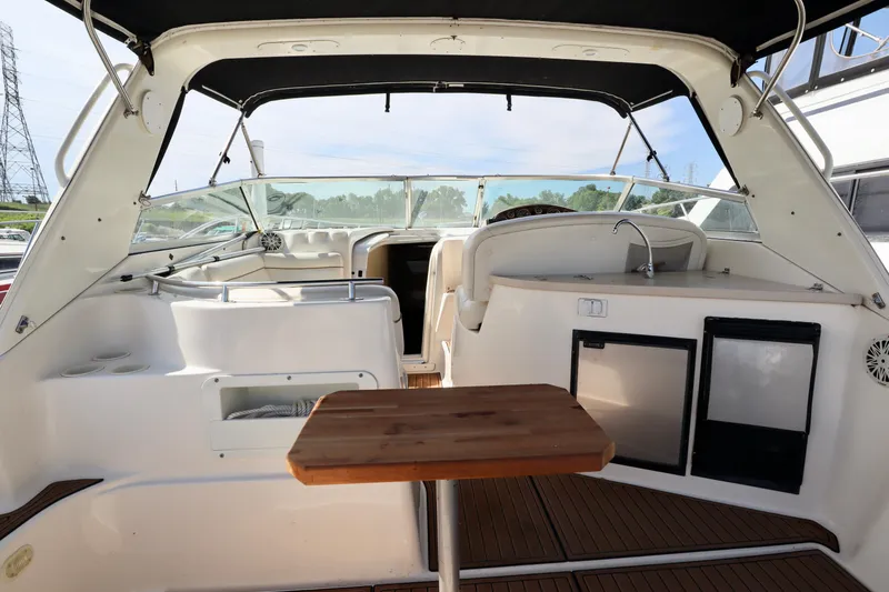 Slide: The Image of Interior of 2002 Rinker 342 Fiesta Vee boat with seating, table, and kitchenette. - 16