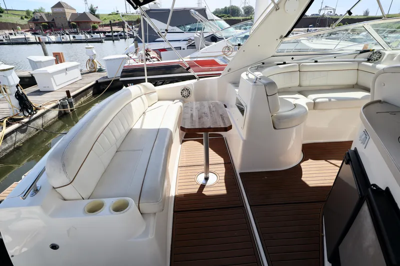 Slide: The Image of Interior of 2002 Rinker 342 Fiesta Vee boat with white seating and wooden table. - 18