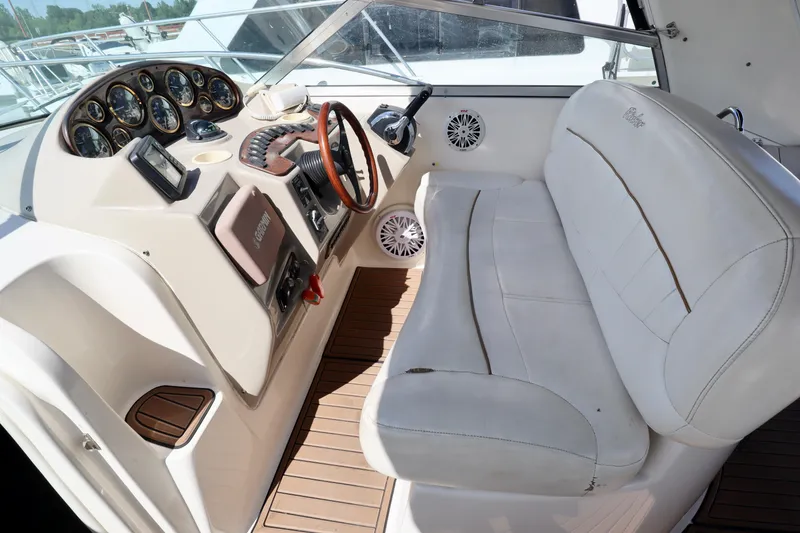 Slide: The Image of 2002 Rinker 342 Fiesta Vee boat cockpit with steering wheel and white seating. - 19