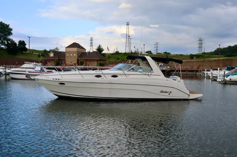 Slide: The Image of 2002 Rinker 342 Fiesta Vee boat docked in a marina under cloudy skies. - 2