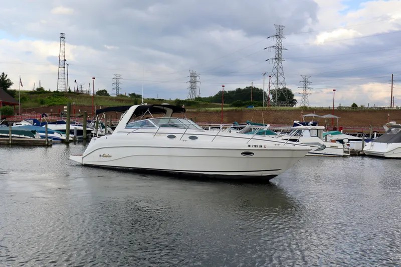 Slide: The Image of 2002 Rinker 342 Fiesta Vee boat docked in a marina under cloudy skies. - 23
