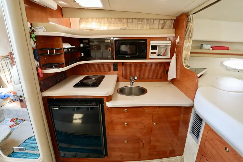 Slide: The Image of 2002 Rinker 342 Fiesta Vee boat kitchen with microwave, sink, stove, and refrigerator. - 7
