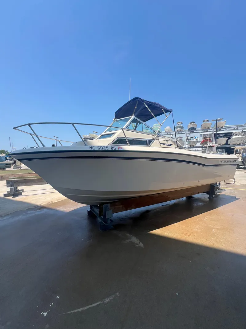Slide: The Image of 1989 Grady-White Seafarer 226 boat on a dock under a clear blue sky. - 9