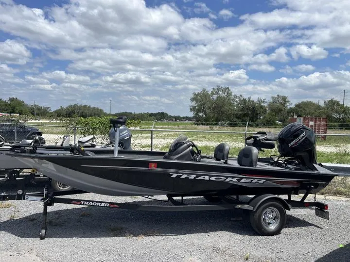 Slide: The Image of 2024 Tracker Pro Team 175 TF fishing boat on trailer under a partly cloudy sky. - 4
