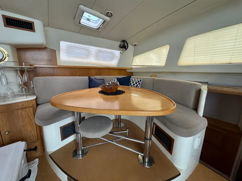 Slide: The Image of Cozy dining area in 2003 Leopard 47 yacht with modern furnishings and natural light. - 10