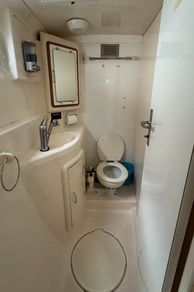 Slide: The Image of 2003 Leopard 47 yacht bathroom with sink, mirror, and toilet. - 12