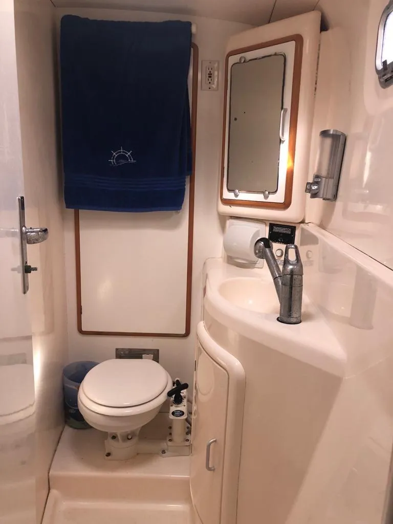 Slide: The Image of Compact bathroom in 2003 Leopard 47 yacht with toilet, sink, and mirror. - 18