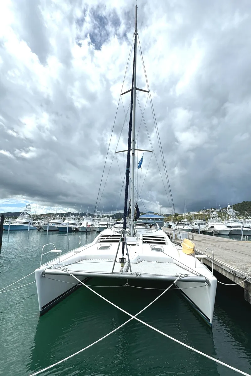 Slide: The Image of Leopard 47 catamaran docked at marina, cloudy sky, 2003 model. - 2