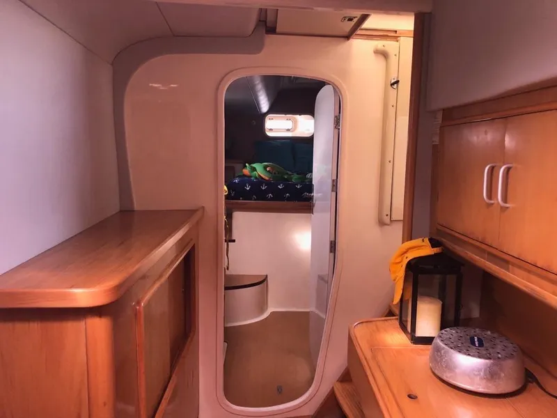 Slide: The Image of Interior of 2003 Leopard 47 yacht, featuring wooden cabinetry and cozy sleeping area. - 29