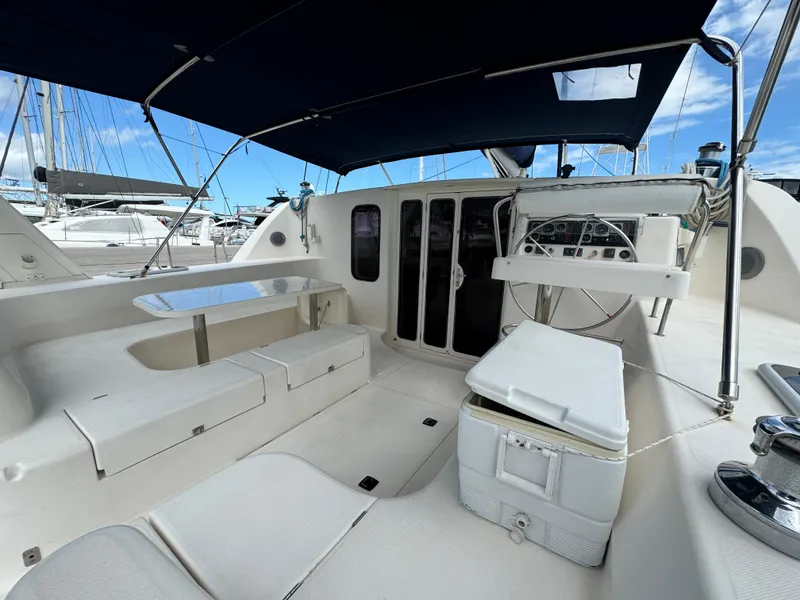 Slide: The Image of 2003 Leopard 47 yacht cockpit with seating, table, and helm under a blue canopy. - 3
