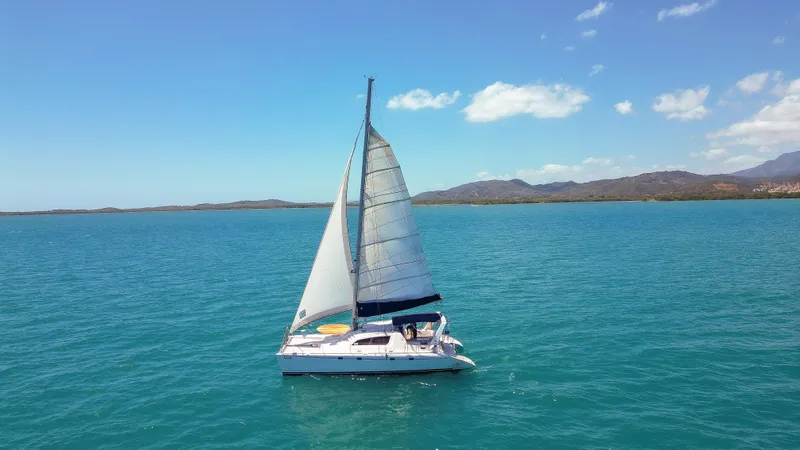 Slide: The Image of Sailing catamaran Leopard 47, 2003 model, cruising on clear blue ocean waters. - 36