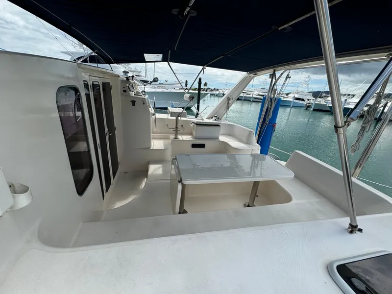 Slide: The Image of Leopard 47 catamaran deck, 2003 model, featuring spacious seating and marina view. - 4