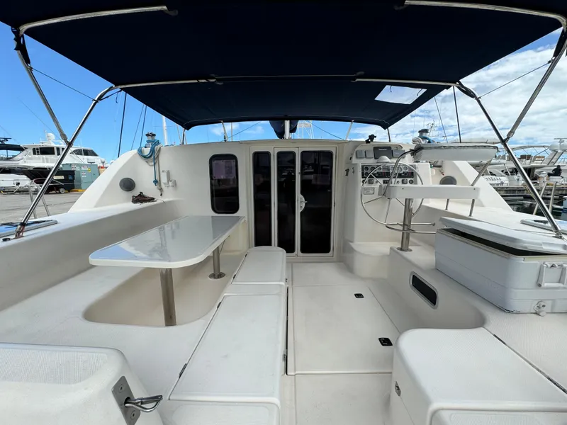 Slide: The Image of 2003 Leopard 47 catamaran cockpit with seating, table, and canopy. - 5