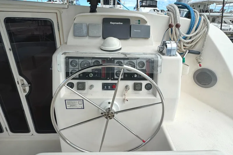 Slide: The Image of Steering wheel and controls of a 2003 Leopard 47 catamaran yacht. - 6