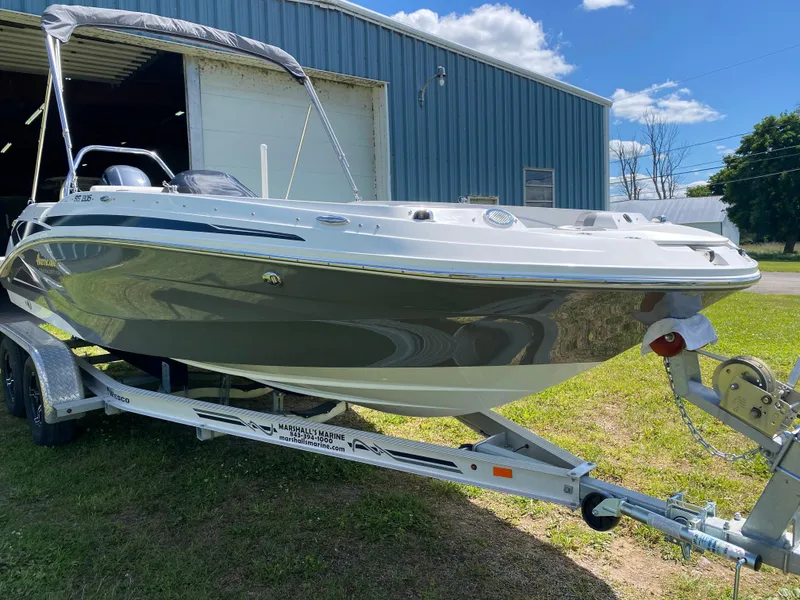 Slide: The Image of 2022 Hurricane SS 205 boat on trailer, parked outside a blue warehouse. - 4