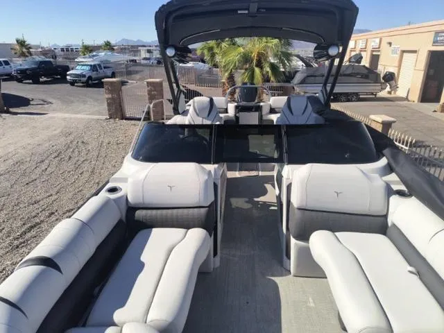 Slide: The Image of 2024 Tahoe Cascade Quad Lounge Windshield 25 FT boat rear view with seating and cup holders. - 17