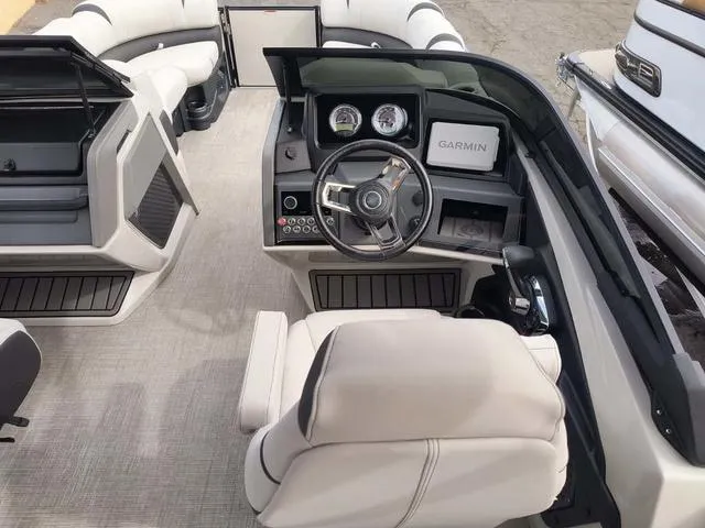 Slide: The Image of 2024 Tahoe Cascade Quad Lounge boat interior with Garmin navigation system and modern dashboard. - 24