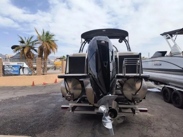 Slide: The Image of 2024 Tahoe Cascade Quad Lounge Windshield 25 FT boat, rear view, parked outdoors. - 25