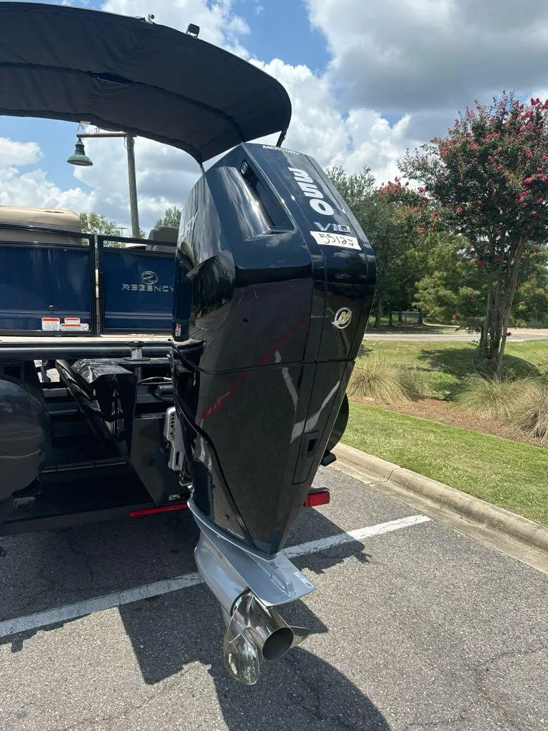 Slide: The Image of 2024 Regency 250 LE3 boat with powerful outboard motor in a parking lot. - 1