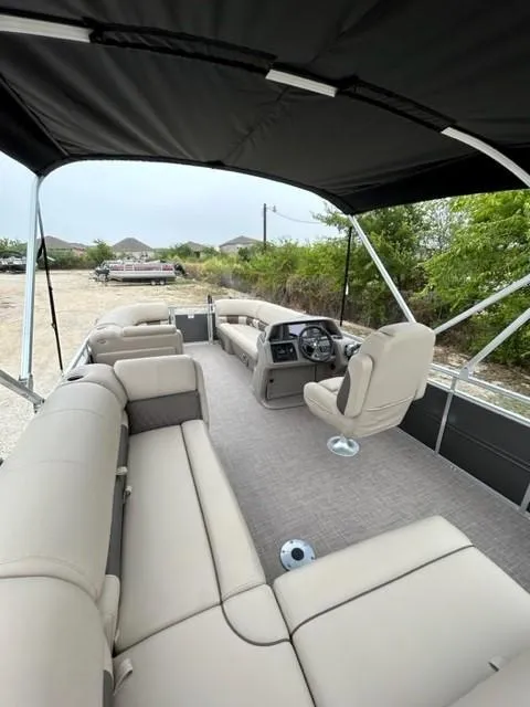 Slide: The Image of 2024 Sun Tracker Party Barge 20 DLX interior with spacious seating and helm. - 7
