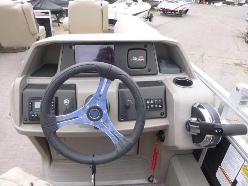 Slide: The Image of 2024 Sun Tracker Sportfish 24 XP3 dashboard with steering wheel and controls. - 13