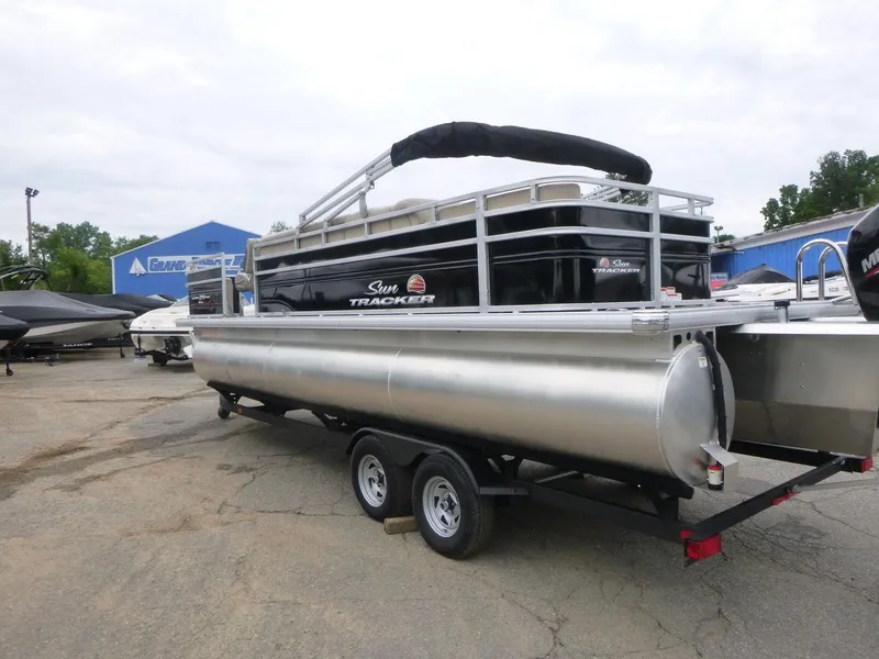 Slide: The Image of 2024 Sun Tracker Sportfish 24 XP3 pontoon boat on trailer in outdoor setting. - 7