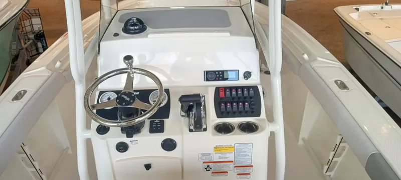 Slide: The Image of 2024 Mako 214 CC boat console with steering wheel and control panel. - 4