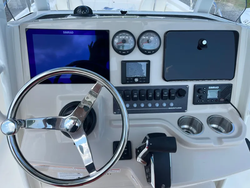Slide: The Image of 2024 Boston Whaler 250 Dauntless boat dashboard with steering wheel and control panel. - 5