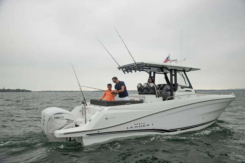 Slide: The Image of 2024 Jeanneau Leader 10.5 CC boat on water with people fishing. - 2