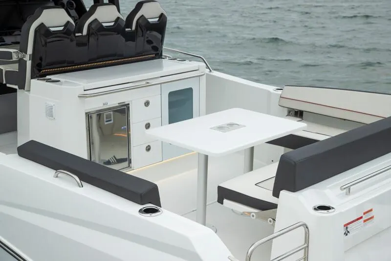 Slide: The Image of 2024 Jeanneau Leader 10.5 CC boat interior with seating and table. - 3