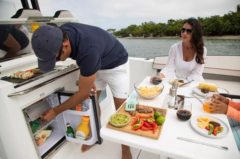 Slide: The Image of People enjoying a meal on a 2024 Jeanneau Leader 10.5 CC boat. - 5