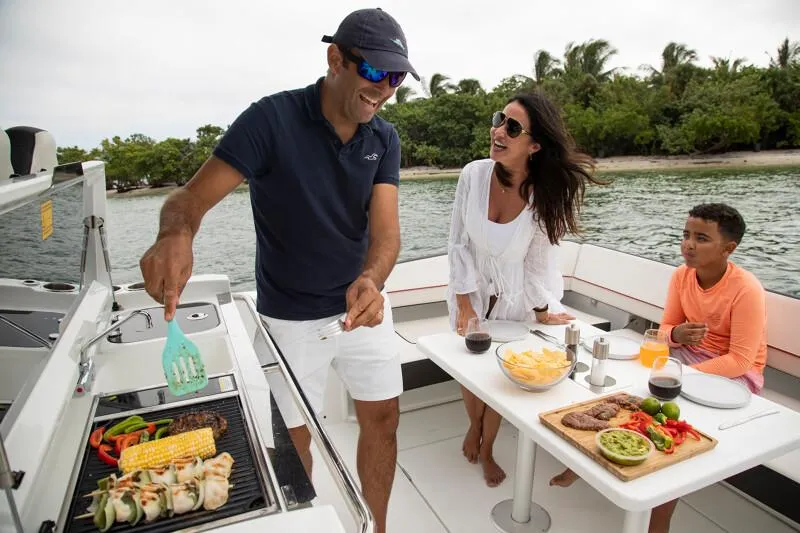Slide: The Image of Family enjoying a barbecue on a 2024 Jeanneau Leader 10.5 CC boat. - 6