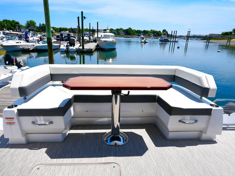 Slide: The Image of 2021 Cruisers Yachts 50 Cantius rear deck seating area with table, docked at marina. - 11