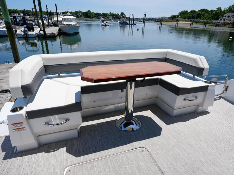 Slide: The Image of 2021 Cruisers Yachts 50 Cantius aft deck seating with table, docked at marina. - 12