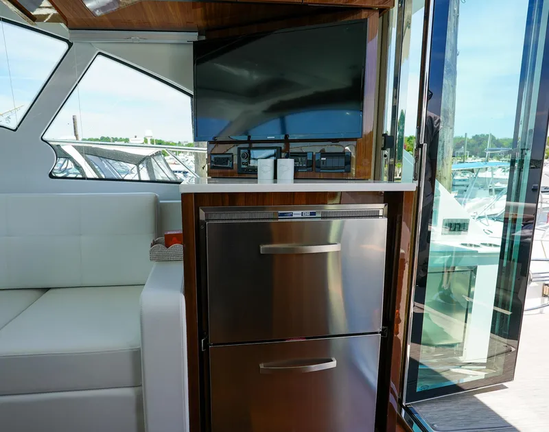 Slide: The Image of Interior of 2021 Cruisers Yachts 50 Cantius with TV and stainless steel fridge. - 21