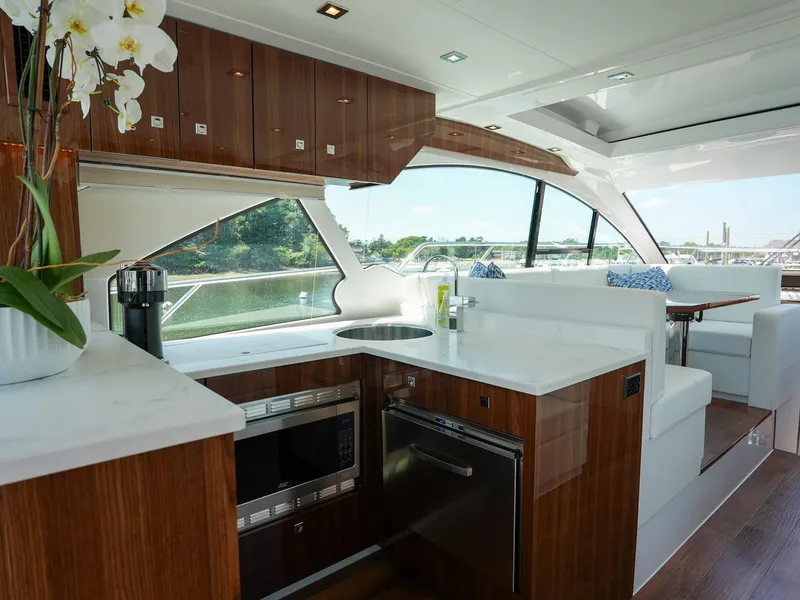Slide: The Image of Luxurious kitchen and dining area inside the 2021 Cruisers Yachts 50 Cantius. - 22