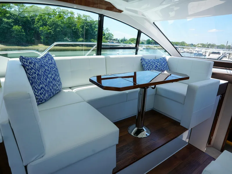 Slide: The Image of 2021 Cruisers Yachts 50 Cantius interior with white seating and wooden table. - 29