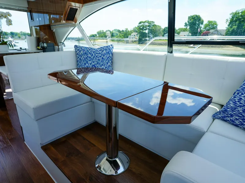 Slide: The Image of Luxurious interior of 2021 Cruisers Yachts 50 Cantius with white seating and wooden table. - 30