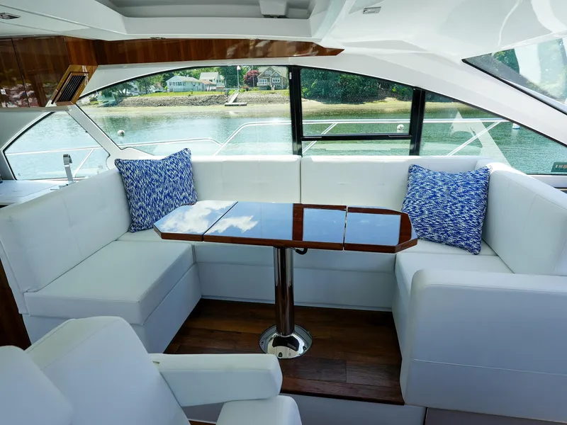 Slide: The Image of 2021 Cruisers Yachts 50 Cantius interior with white seating and wooden table. - 31
