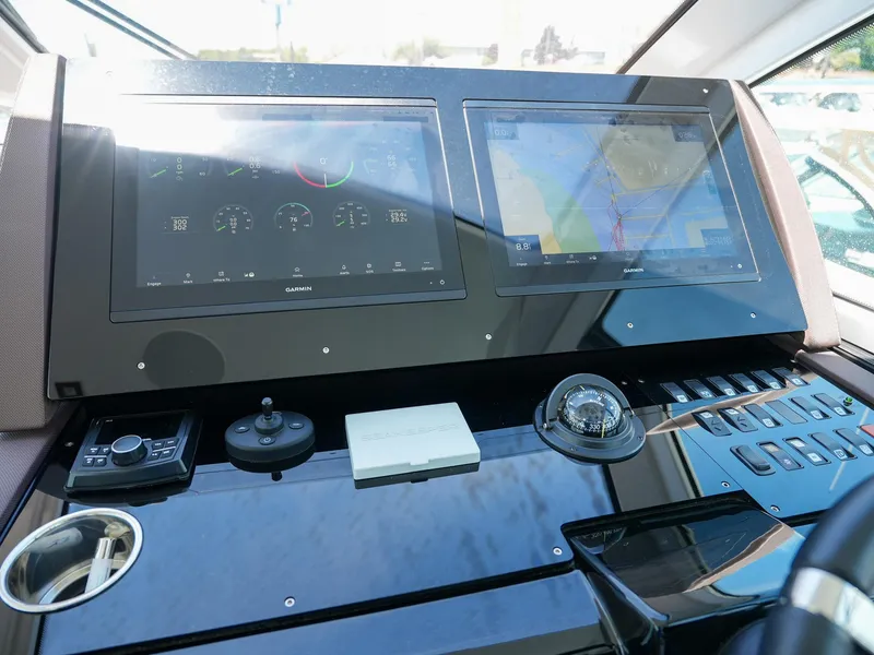 Slide: The Image of 2021 Cruisers Yachts 50 Cantius helm with dual touchscreen displays and navigation controls. - 37
