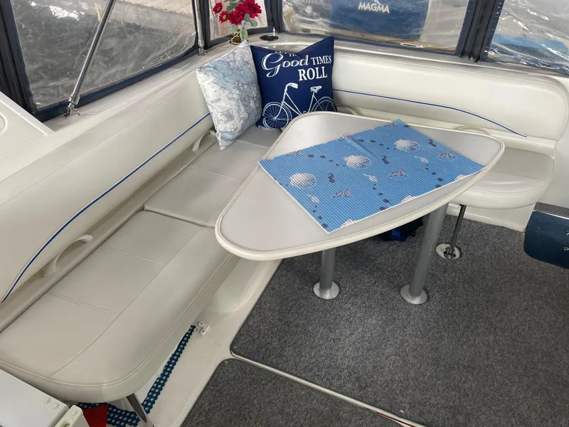 Slide: The Image of Interior seating area of a 2008 Bayliner 340 boat with table and cushions. - 12