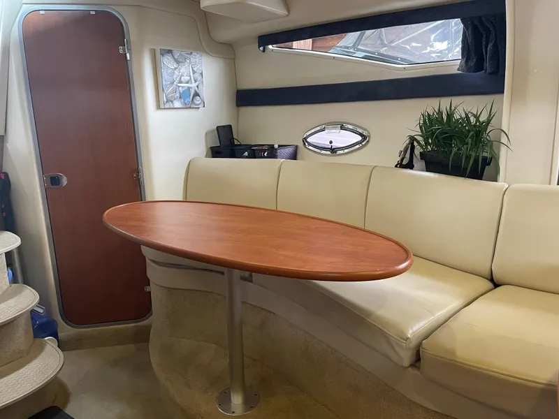 Slide: The Image of 2008 Bayliner 340 interior with beige seating and wooden table. - 19