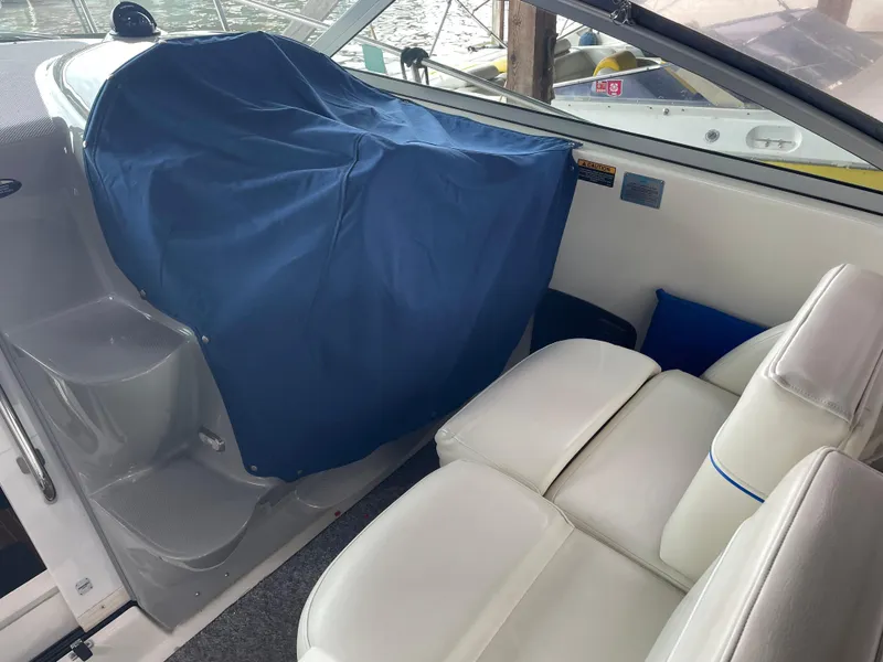 Slide: The Image of Interior of a 2008 Bayliner 340 boat with white leather seats and blue cover. - 2