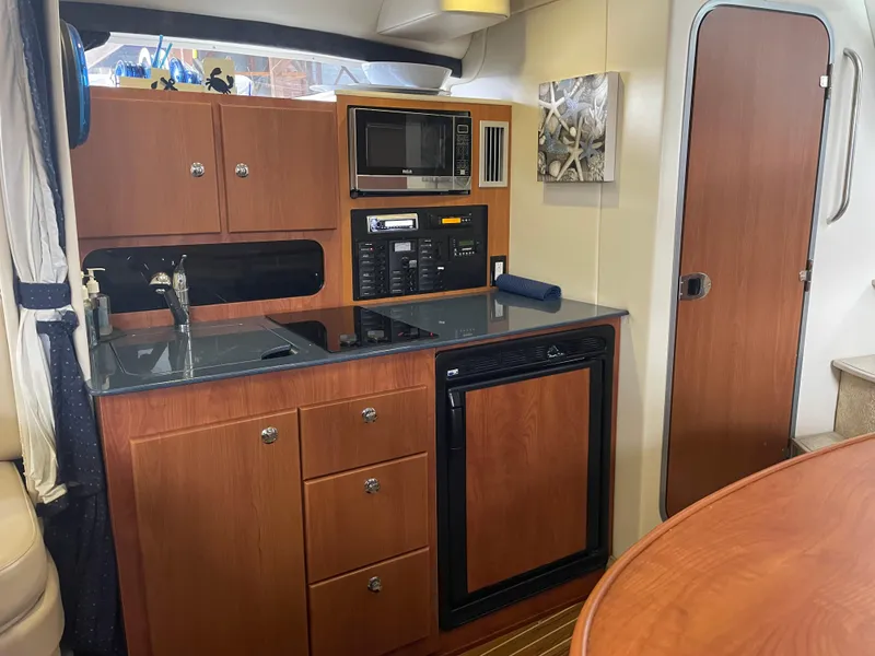 Slide: The Image of 2008 Bayliner 340 yacht kitchen with microwave, sink, and refrigerator. - 24