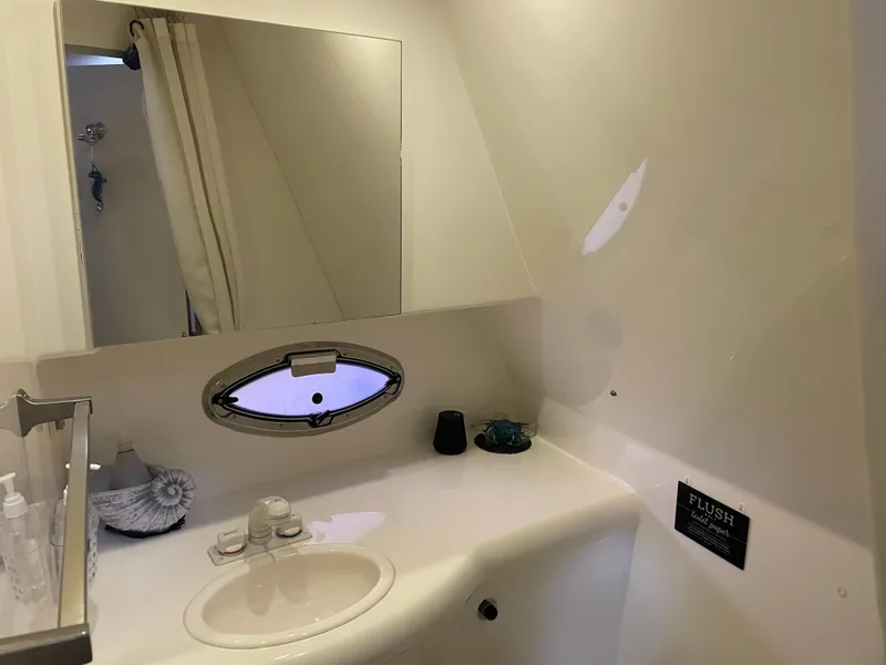 Slide: The Image of Bathroom interior of a 2008 Bayliner 340 boat with sink, mirror, and porthole window. - 32